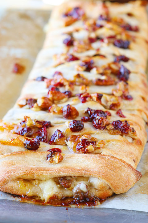 This beautiful Harvest Breakfast Braid is perfect for breakfast, brunch, or even dinner! Layers of sausage, apple, and havarti cheese make for the perfect sweet and salty combo. It's all topped with cranberries and pecans in a sweet orange marmalade glaze.