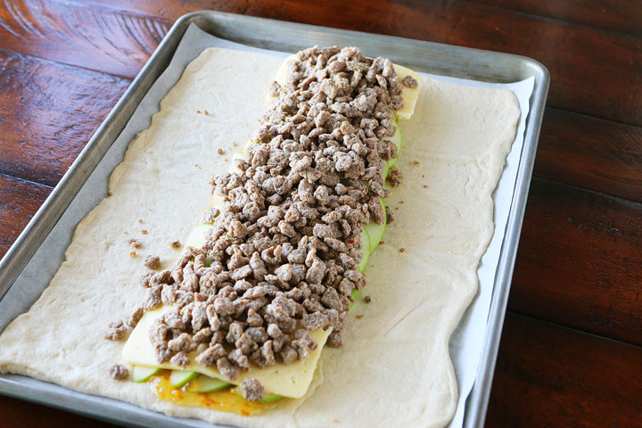 This beautiful Harvest Breakfast Braid is perfect for breakfast, brunch, or even dinner! Layers of sausage, apple, and havarti cheese make for the perfect sweet and salty combo. It's all topped with cranberries and pecans in a sweet orange marmalade glaze.