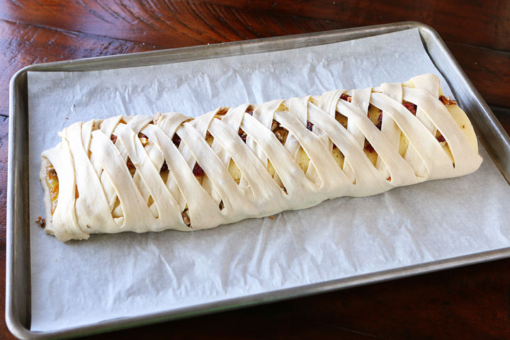 This beautiful Harvest Breakfast Braid is perfect for breakfast, brunch, or even dinner! Layers of sausage, apple, and havarti cheese make for the perfect sweet and salty combo. It's all topped with cranberries and pecans in a sweet orange marmalade glaze.